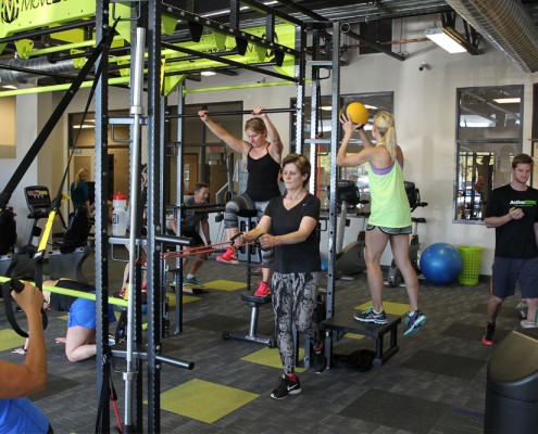 people performing exercises with gym equipment in health club
