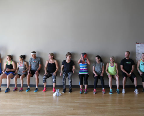 people along wall perform wall squat exercise