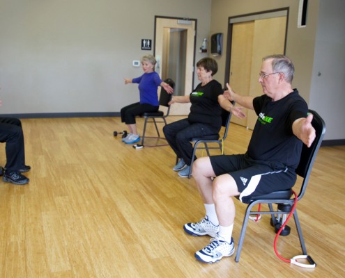 People performing seated shoulder exercises