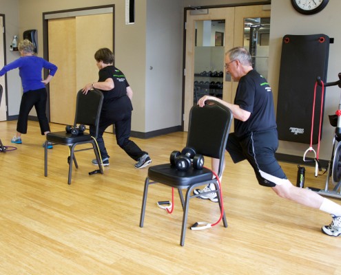 people performing lunge exercise in gym room