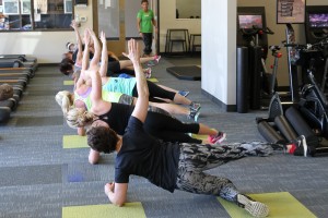 People performing side plank yoga pose